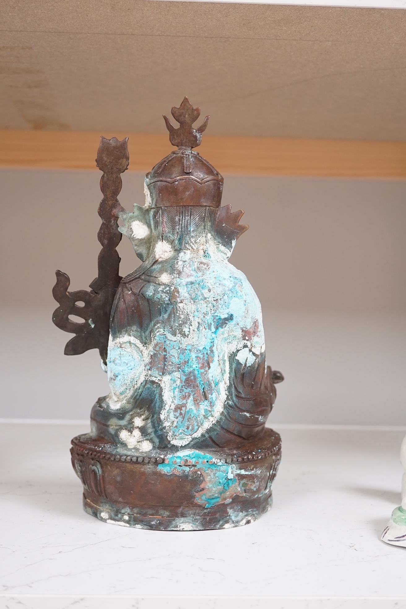 A Tibetan bronze Padmasambhava Buddhist figure, 29.5cm high. Condition - poor to fair.